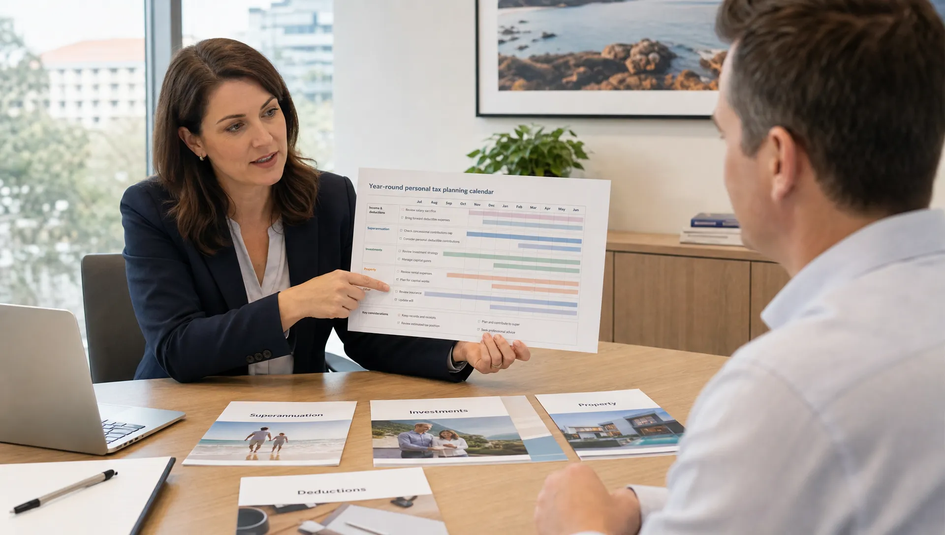An Australian professional reviewing a year-round personal tax planning calendar with documents for superannuation, investments, property and deductions arranged on a meeting table in a bright advisory office.
