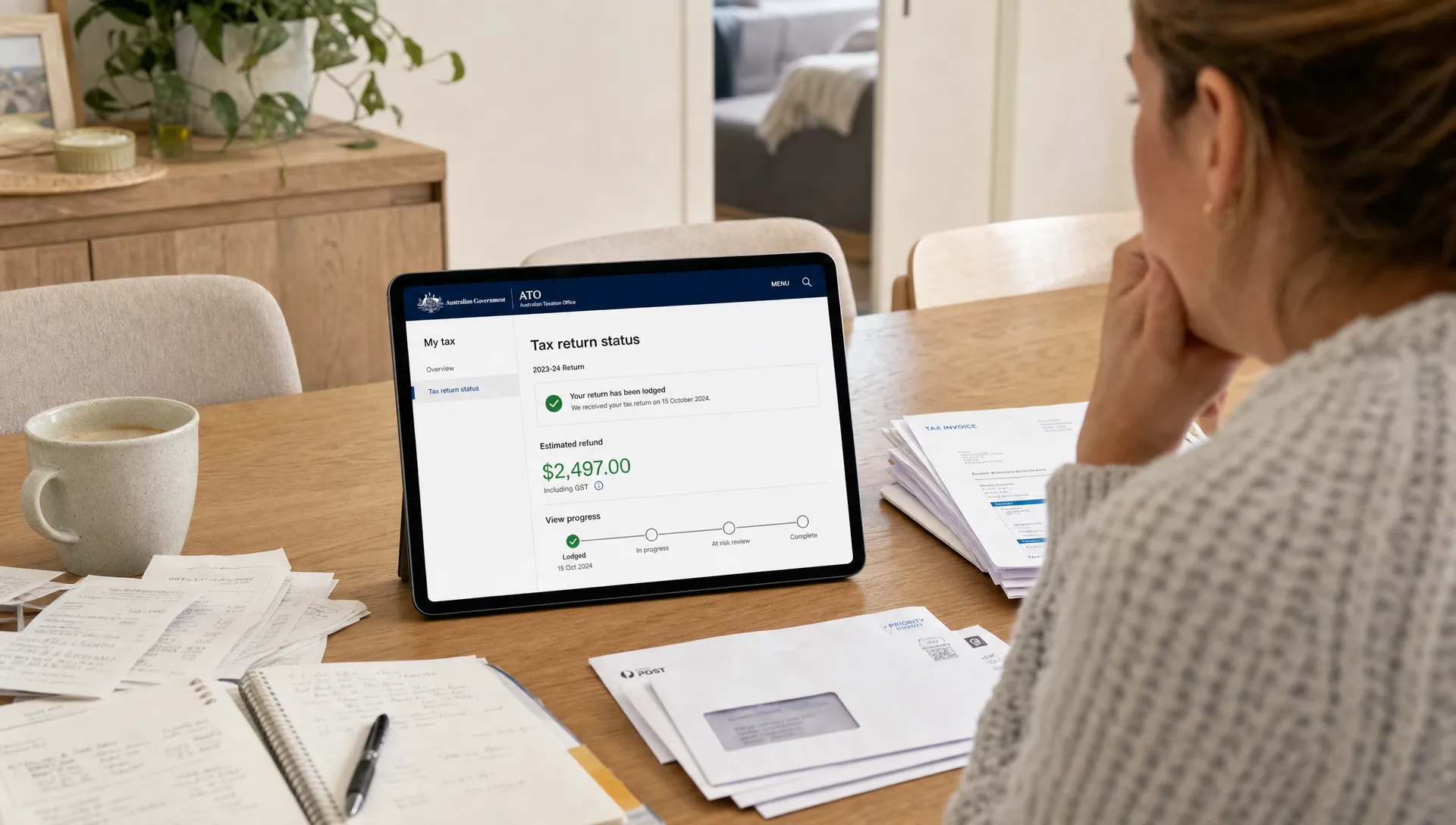 a-sole-trader-checks-tax-return-status-at-a-home-t-03b503b8-1789771011431 A sole trader checks tax return status at a home table with receipts, invoices and household mail.